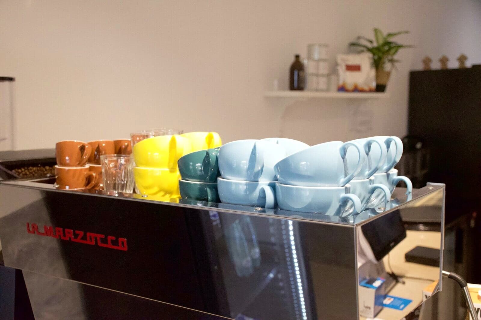 Tazas de colores sobre la máquina La Marzocco