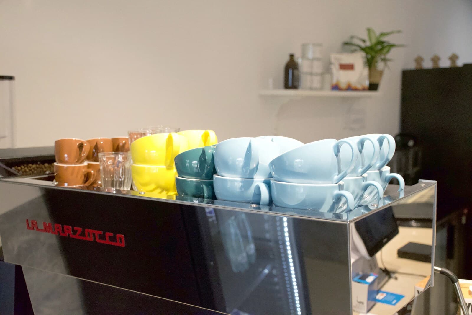 Tazas de colores sobre la máquina La Marzocco
