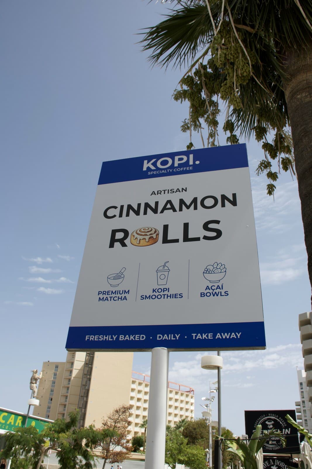 El cartel de KOPI. Artisan Cinnamon Rolls bajo el cielo de Magaluf